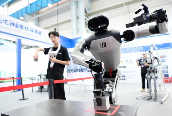 9月5日，在沈陽的2025全球工業(yè)互聯(lián)網(wǎng)大會(huì)的展覽區(qū)現(xiàn)場(chǎng)，中國科學(xué)院沈陽自動(dòng)化研究所的機(jī)器人工程師在調(diào)試具身智能操作系統(tǒng)。新華社記者 李鋼 攝