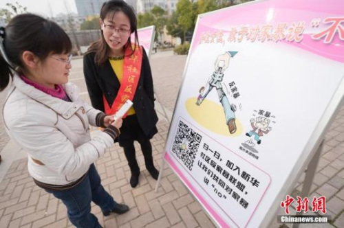 資料圖：今年3月8日，安徽合肥新華社區(qū)志愿者夏一瓊(右)向市民普及反家暴相關(guān)法律知識(shí)。鐘欣 攝