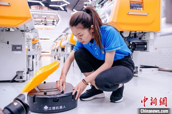 圖為員工在調(diào)試AGV搬運機器人?！±钅宪?攝